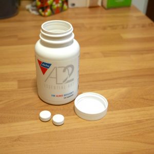 A bottle of Essential AD2 for ALDH2 deficiency sits on a table